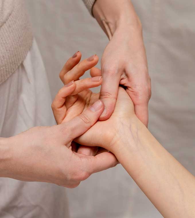 Practitioner applying acupressure to a client’s hand