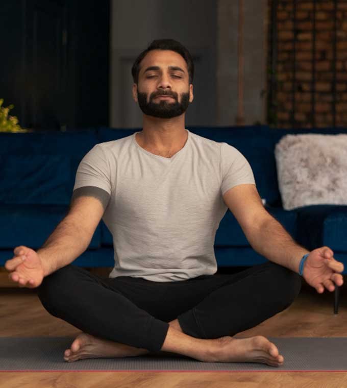 Man meditating cross-legged on a yoga mat